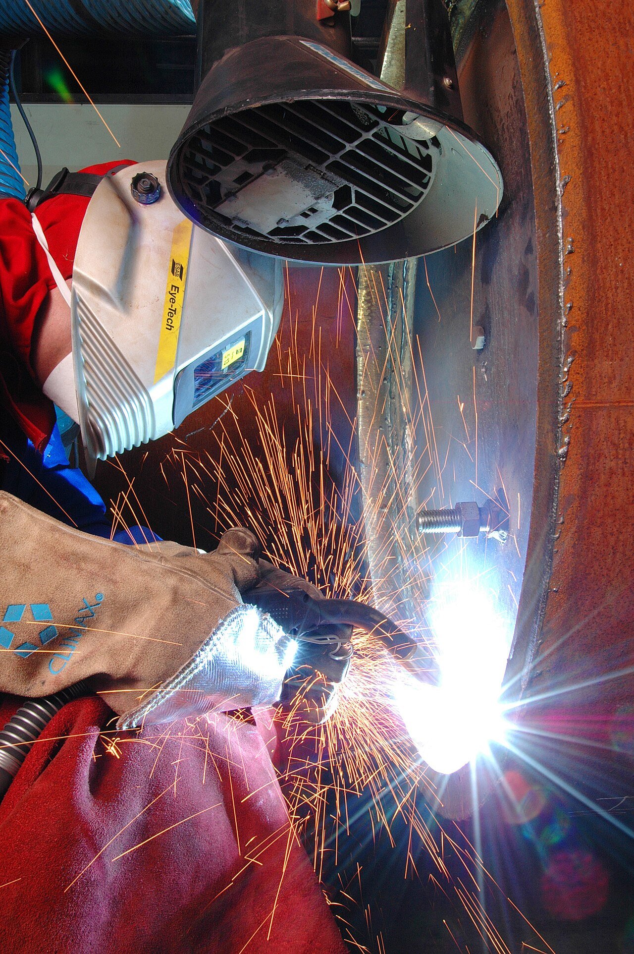Artisan hand-welding an iron plant stand